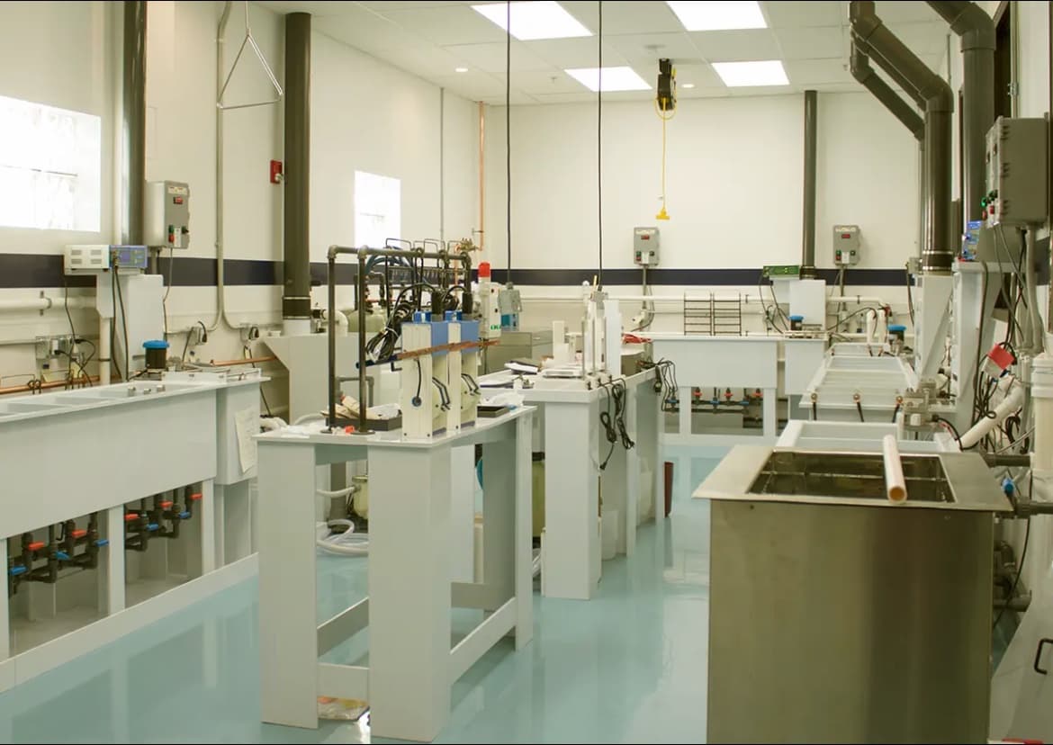 Inside the Gold Plating US lab in San Diego: plating tanks, rectifiers, and fume extraction over an epoxy floor